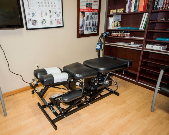 Adjustment Table Patient exam room with adjustment table in the center at Wesley Chapel Medical Injury Center: Augustine Chiropractic.
