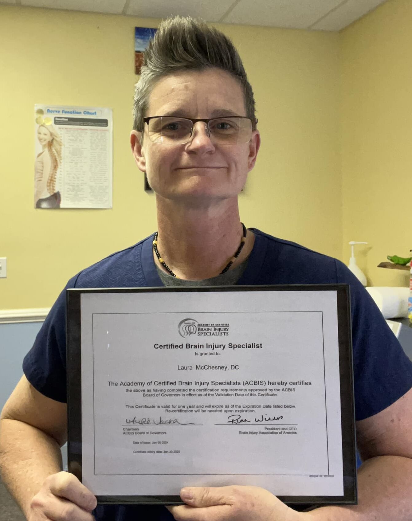 Dr. Laura McChesney, of Gainesville Medical Injury Center: Momentum Rehab & Chiropractic, holding her Brain Injury Specialist Certification from the Brain Injury Association of America.