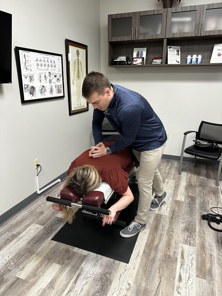 Dr. Nickels giving adjustment Patient lying face down on an adjustment table with Dr. Nickels of Wesley Chapel Medical Injury Center: Augustine Chiropractic giving an adjustment in the center of her back.